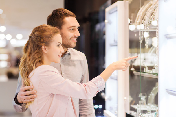 couple looking to shopping window at jewelry store - Fotoğraf, Görsel