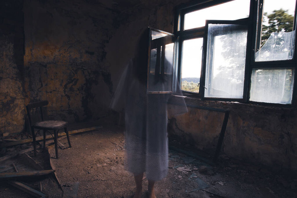 Ghost in abandoned, haunted house. Horror scene of scary spirit of a woman, halloween concept. - Φωτογραφία, εικόνα