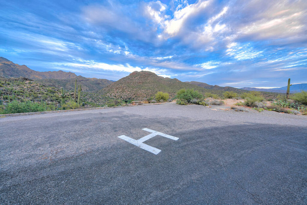Helipad at Sabino Canyon State Park in Tucson, Arizona. Emergency helicopter landing with a view of mountain range with saguaro cactuses on the slope against the sky. - Foto, Imagem