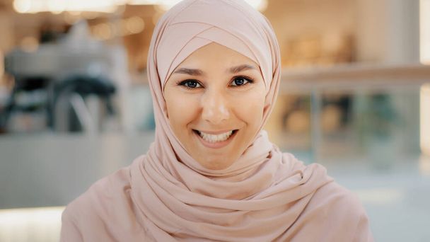 Webcam view young arab muslim woman in hijab speaks looking at camera smiling girl talking on cam job interview female entrepreneur explaining terms of contract by videoconference online presentation - Zdjęcie, obraz