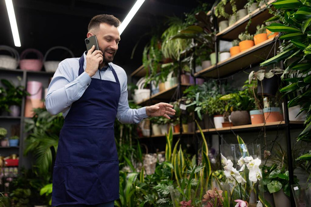 flower shop employee talking on the phone. - Photo, Image