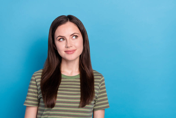 Photo of funny young brunette lady look up wear green t-shirt isolated on blue color background. - Fotografie, Obrázek