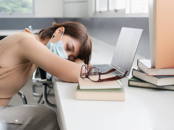 Woman with tried feeling, Napping between using laptop and searching data from text book,at library - Photo, Image