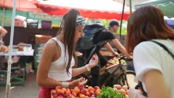 Жінка-продавець пропонує ринок свіжих та органічних овочів фермерів. Молодий покупець вибирає і купує продукти для здорового харчування в продуктовому магазині
. - Кадри, відео