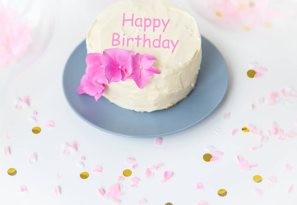 Very beautiful small white bento cake, decorated with fresh flowers of pink hydrangeas. Happy birthday lettering - Photo, Image