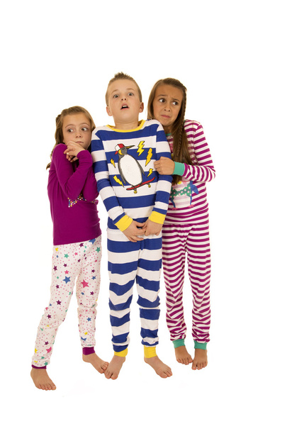 drei Kinder, die im Weihnachtsschlafanzug standen, erschraken exp - Foto, Bild