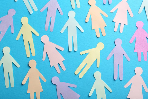 Many different paper human figures on light blue background, flat lay. Diversity and inclusion concept - Foto, Bild