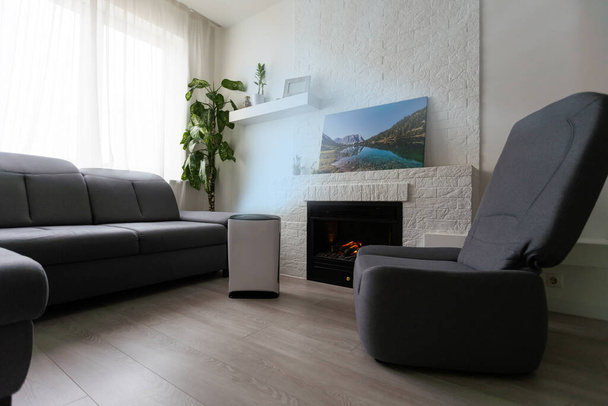 Εξαγνιστής αέρα σε άνετο χώρο για φιλτράρισμα και καθαρισμό αφαιρώντας τη σκόνη PM2.5 HEPA στο σπίτι, για καθαρό αέρα και υγιή ζωή, Air Pollution Concept. - Φωτογραφία, εικόνα