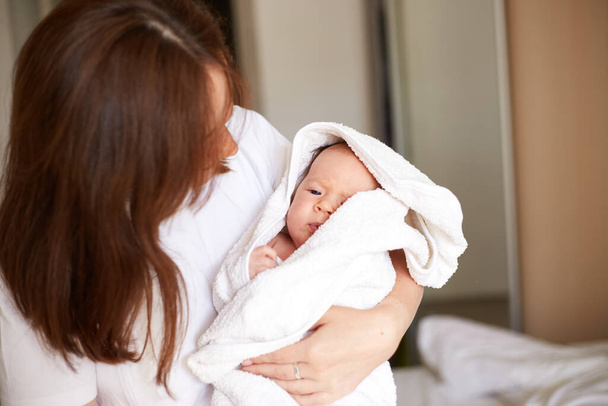 Mother holding her newborn baby. Home portrait of newborn baby and mother. Enjoying time together - Foto, Imagen