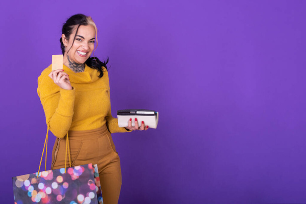 Женщина, держащая кошелек и сумку с покупками, показывая кредитку. Концепция покупок. Снимок студии. - Фото, изображение