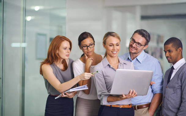 Manager with laptop showing, training or presenting strategy ideas or brainstorm plans with diverse group of office colleagues. Confident, smiling or happy leader updating team of staff on technology. - Foto, Imagen