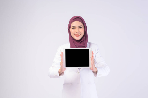 Kaunis muslimi liiketoiminnan nainen yllään valkoinen puku hijab tilalla tabletti studiossa - Valokuva, kuva