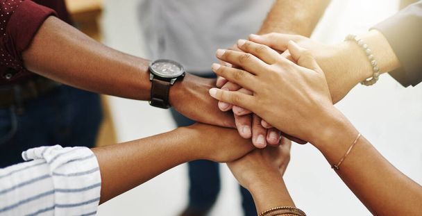 Diverse people stacking or piling hands in teamwork, success and support to show solidarity, trust and unity in office. Closeup of business team, men and women standing together and feeling motivated. - Photo, Image