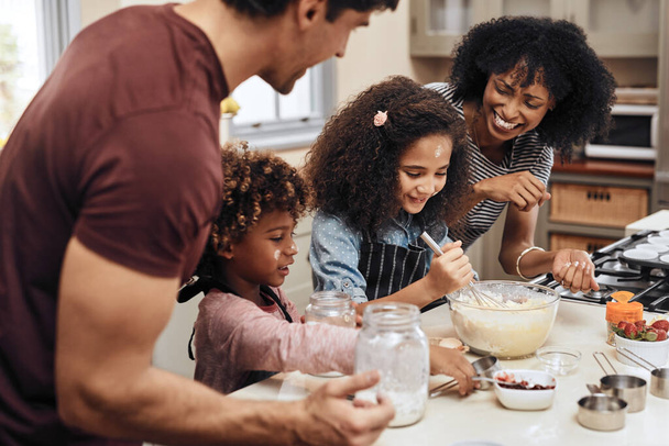 Провести день, пекая как семья. молодая пара печет дома со своими двумя детьми - Фото, изображение