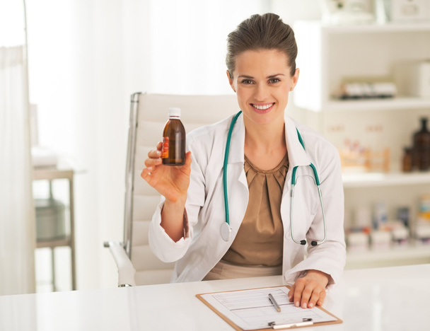 Sorridente medico donna mostrando bottiglia medicina
 - Foto, immagini