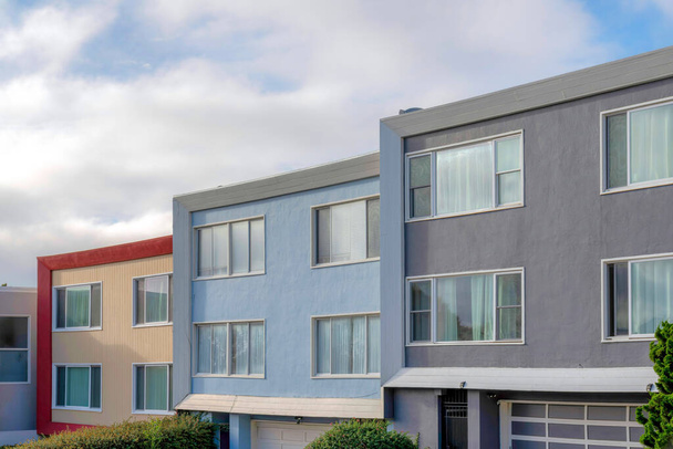 Modern house buildings with reflective picture windows in San Francisco, California. Complex houses with a view of garage doors at the bottom against the sky background. - Foto, immagini