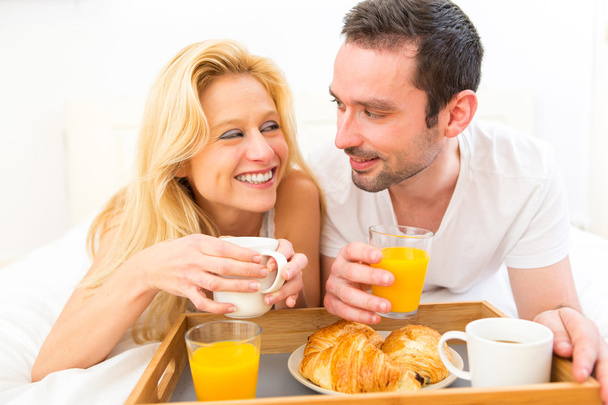 Portrait of a couple having breakfast in bed - Zdjęcie, obraz