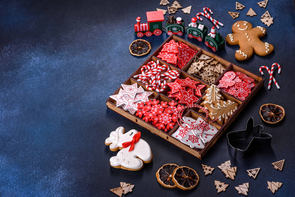 Χριστουγεννιάτικα παιχνίδια σε λευκό και κόκκινο σε ξύλινο κουτί σε σκούρο μπετόν φόντο. Διακόσμηση για τις διακοπές των Χριστουγέννων - Φωτογραφία, εικόνα