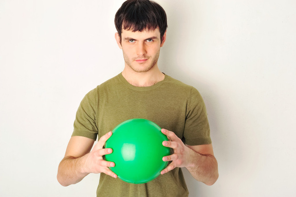 portret przystojny mężczyzna trzyma zielony piłkę w ręce. stojącą - Zdjęcie, obraz