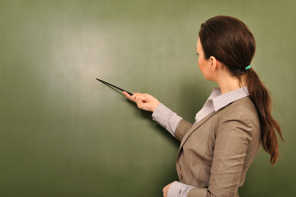Portrait of young woman teacher standing near blackboard and exp - Photo, image