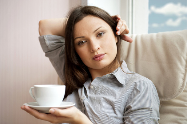 Young woman at home sipping tea from a cup - Foto, Imagem