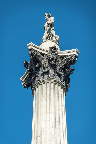 London, UK- 4 липня 2022: Трафальгарська площа. Зображення статуї Нельсона на вершині колони Нельсона проти блакитного неба.. - Фото, зображення