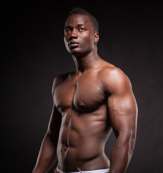 Beautiful and muscular black man in dark background - Zdjęcie, obraz