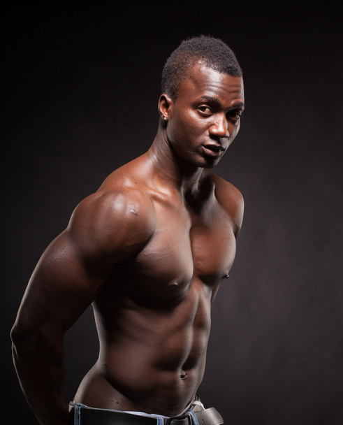 Beautiful and muscular black man in dark background - 写真・画像