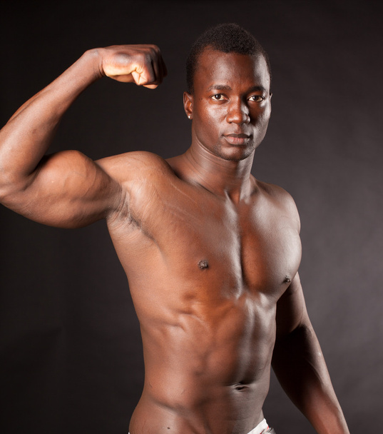 Beautiful and muscular black man in dark background - Foto, imagen
