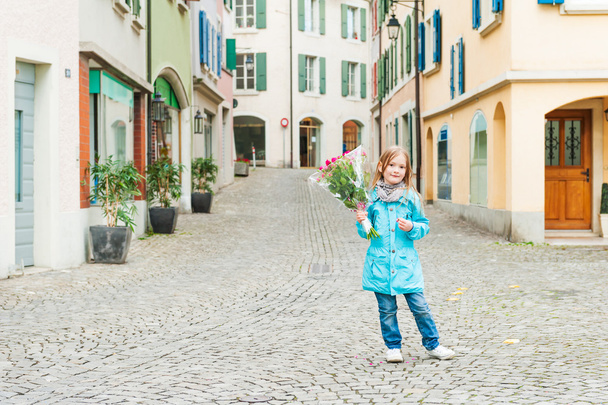 Outdoor portrait of a cute little girl in a city - Photo, Image
