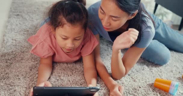 Close-up Asia toddler little girl daughter with mother play on digital tablet on carpet floor having fun, joyful in living room at home. Family spend time together, Creative lifestyle for kid concept. - Séquence, vidéo