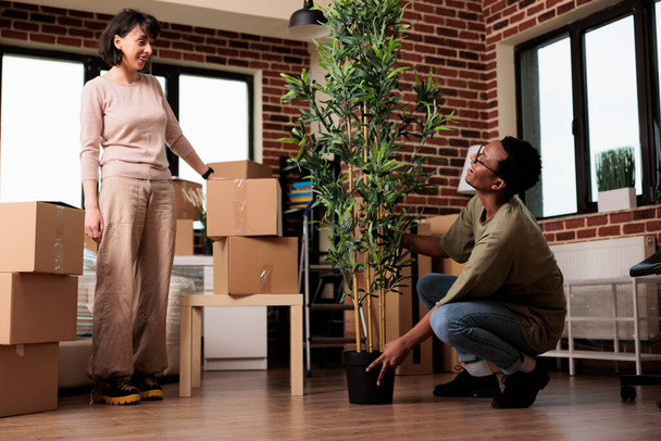 Husband and wife feeling happy about moving in together in rented flat, using mortgage payment for property relocation. Moving day to start new beginnings in real estate household. - 写真・画像