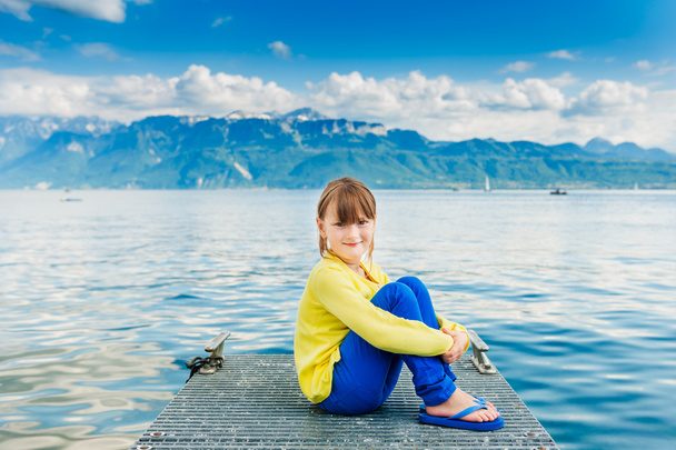 Ritratto all'aperto di una bambina carina, con indosso un top giallo e pantaloni blu
 - Foto, immagini