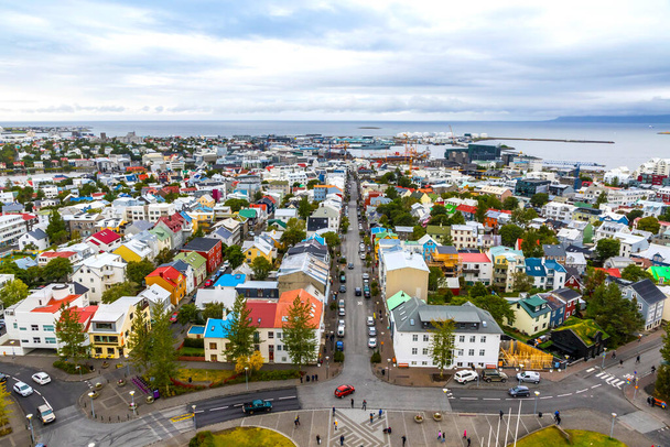 Skyline aerial view of Reykjavik city, Iceland. Skolavordustigur street, downtown, central streets, harbor and ocean scenery beyond the city. View from Hallgrimskirkja Cathedral - Photo, image