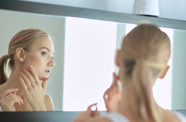 Face of young beautiful healthy woman and reflection in the mirror. - Foto, imagen