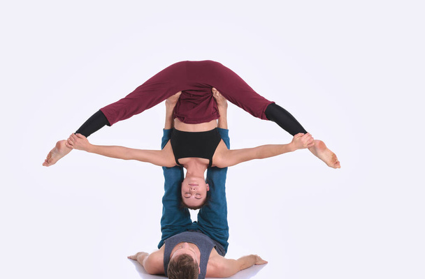 Young athletic couple practicing acroyoga. Balancing in pair. - Foto, Imagem