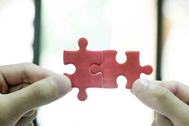 Close up of business people assemble jigsaw puzzle find perfect match, business solution, diverse employees put pieces together engaged in team building activity at work, teamwork, creative thinking - Foto, imagen