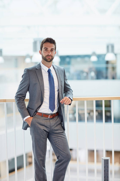 Уверенность в себе создаст вашу карьеру. Портрет уверенного молодого бизнесмена, стоящего в офисе - Фото, изображение