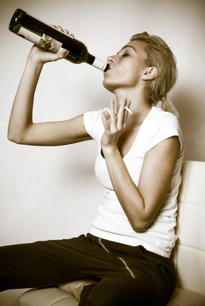Mulher com garrafa de vinho e cigarro
 - Foto, Imagem