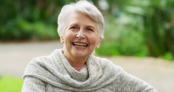 Ευτυχισμένη, ενθουσιασμένη και χαρούμενη ηλικιωμένη γυναίκα που απολαμβάνει τη φύση στην αυλή ενός γηροκομείου. Προσωπογραφία ενός ώριμου και γέρου συνταξιούχου που κάθεται έξω στον κήπο και αισθάνεται υγιής. - Πλάνα, βίντεο