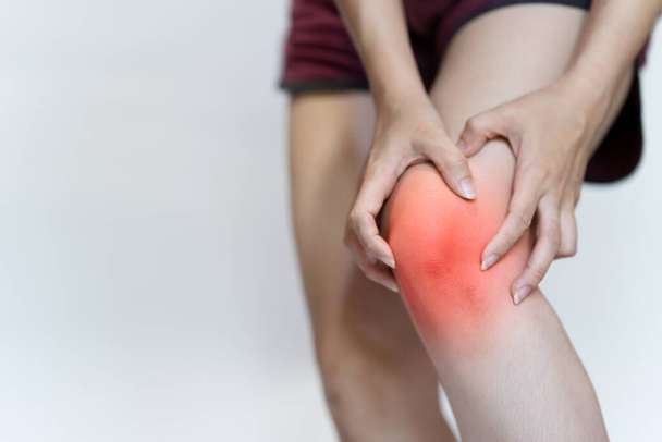 A woman's hand touches her knee due to pain. - Valokuva, kuva