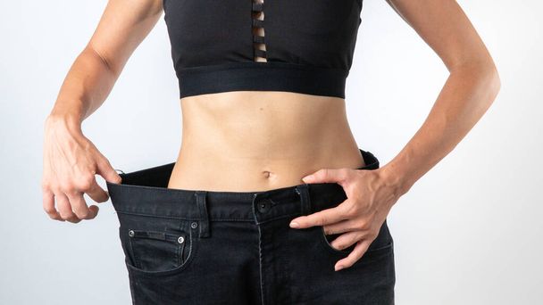 Egy nő egy nagyobb nadrágban - fogyás, karcsú test, fogyókúra után. Kiváló minőségű fénykép - Fotó, kép