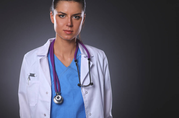 Young doctor woman with stethoscope isolated on grey background. - Fotoğraf, Görsel