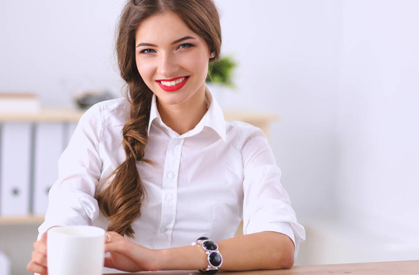 Attractive businesswoman sitting in the office. - Photo, image