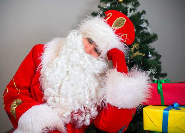 Санта-Клауса спить поруч із новорічні ялинки та подарунки. - Фото, зображення