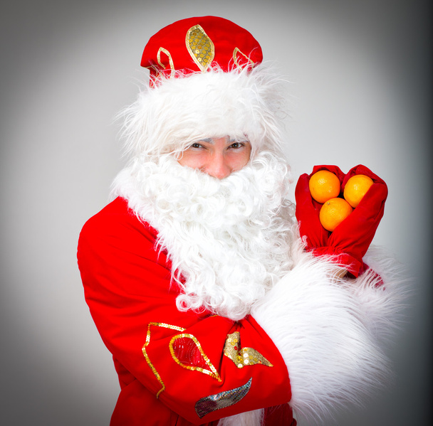 Santa Claus shows heart made of tangerines. - Photo, Image