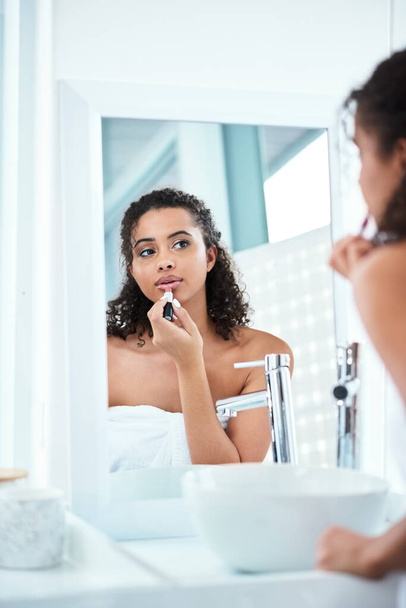 Нічого хорошого відтінку помади не може виправити. красива жінка наносить помаду у своєму дзеркалі у ванній
 - Фото, зображення
