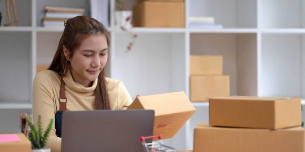Portrait of Starting small businesses SME owners female entrepreneurs working on receipt box and check online orders to prepare to pack the boxes, sell to customers, sme business ideas online - Photo, Image