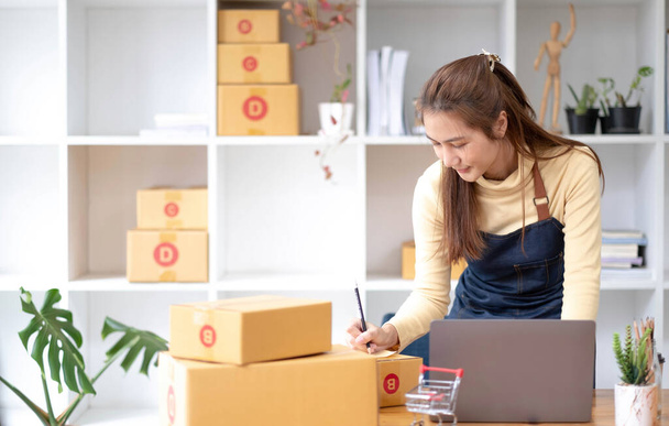Kisvállalkozások indítása KKV-tulajdonosok női vállalkozók Írja le a címet az átvételi dobozra, és ellenőrizze az online megrendeléseket, hogy előkészítse a dobozok csomagolását, eladni az ügyfeleknek, sme üzleti ötletek online - Fotó, kép