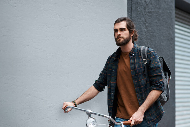 Time to make the city mine. a handsome young man travelling with his bicycle outdoors - 写真・画像
